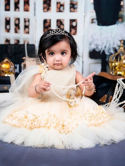 A baby girl, complete with a tiara and pearls, looks every bit the part in this high-fashion themed session.