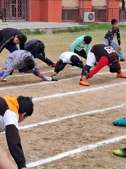 A proper warm-up is non-negotiable. Here, the team is stretching before a friendly match on a grass field to prevent injuries and prepare their muscles for the game.