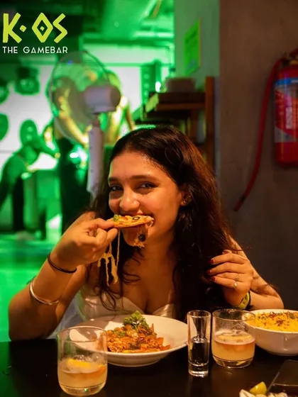 That perfect cheese pull. A guest enjoying a slice of our delicious pizza during our new menu launch party.