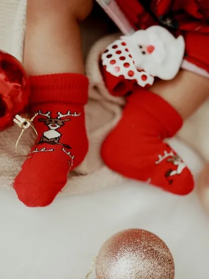 Little Christmas feet! The tiny reindeer socks and festive ornaments make this detail shot extra special for the holidays.