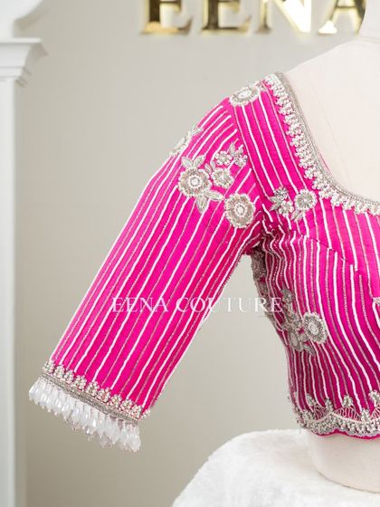 Pretty in pink, this raw silk blouse features intricate pearl and silver thread work in a striped pattern. I added floral motifs and delicate danglers on the sleeves for a touch of playful elegance.