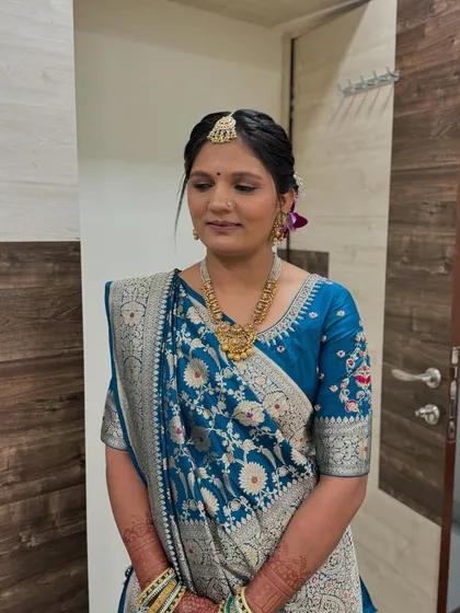 The mother of the bride in a stunning blue saree, with a classic updo and timeless makeup.