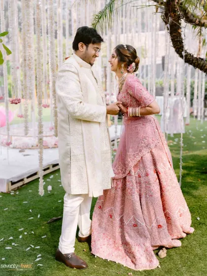 The couple shares a laugh after their varmala ceremony, a candid moment of happiness and relief, surrounded by beautiful floral decor.