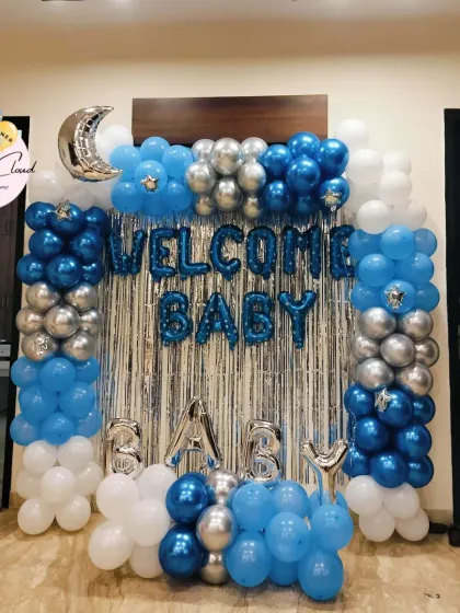 A 'Welcome Baby' boy decoration with a full wall balloon arch, shimmer curtain, and 'BABY' foil letters.