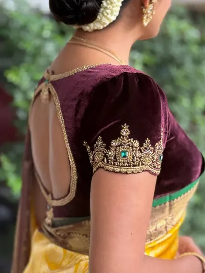 The rich texture of a deep wine velvet blouse, perfect for winter weddings and evening receptions. I focus on creating elegant back designs, like this keyhole cutout, to ensure you look stunning from every angle.