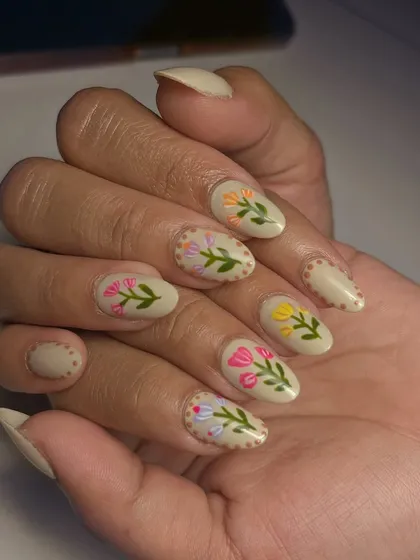 Another look at the delicate floral nail art. The almond shape of the nails perfectly complements the elegant, botanical design.
