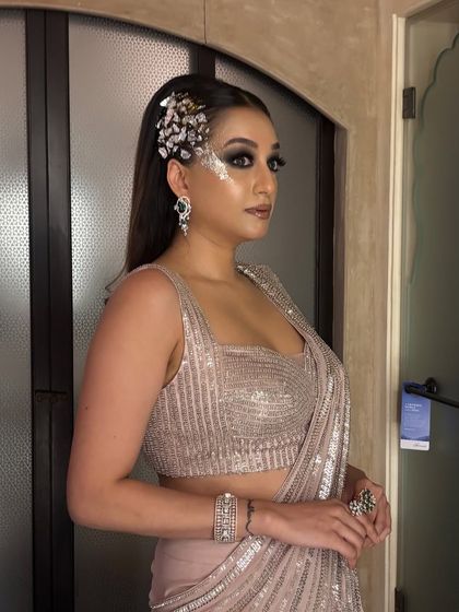 Another view of the sleek side-tuck hairstyle, this time with a dramatic silver hair accessory and matching eye makeup for a high-fashion, edgy cocktail look.