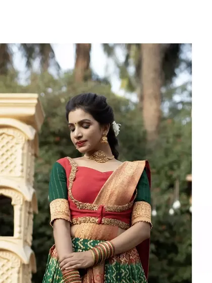 A unique draped ensemble featuring a green brocade and bandhini skirt. The blouse, in contrasting red and green, is adorned with golden glass bead embroidery for a festive look.