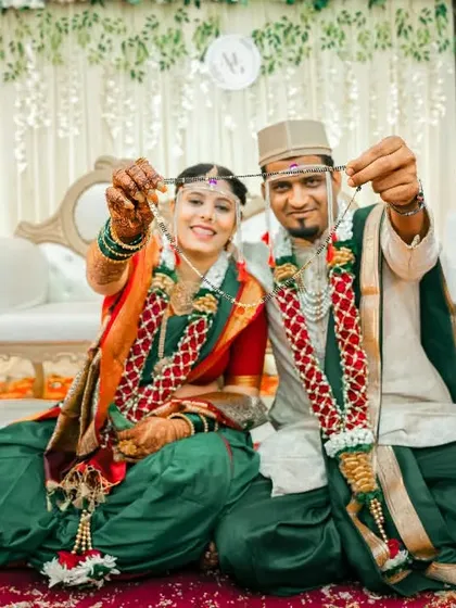 The couple proudly displaying their wedding rings while seated, a fun and important shot from their Maharashtrian wedding ceremony.