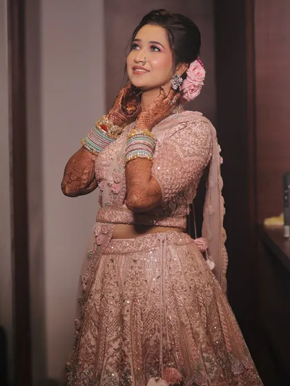 A lovely pose showing the floral hair accessories and the intricate details of her lehenga.