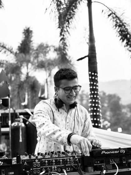 A candid moment of focus, selecting the next track to keep the Baraat procession's energy flowing.