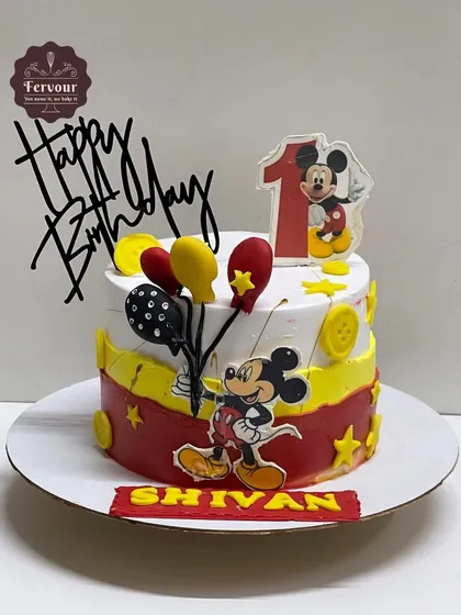 A cheerful Mickey Mouse cake for a first birthday. This chocolate truffle cake is decorated with Mickey, colourful balloons, and stars, making it a perfect choice for a baby's first big celebration.