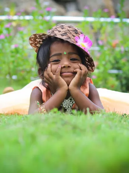 The best moments are the natural ones. For this outdoor child portrait, we went to a park, and I captured this sweet, candid expression as she relaxed in the grass, showing her genuine personality.