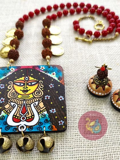 This angle of the Durga necklace set showcases the handcrafted wooden jhumkas and the sacred rudraksha beads that accompany the powerful hand-painted pendant.