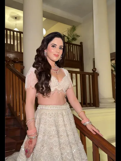 A soft and romantic reception look in a white lehenga with pearl details.