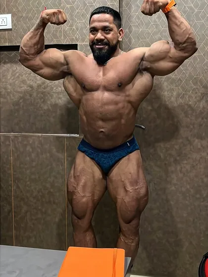 The front double bicep is a mandatory pose that wins shows. Here, I'm 48 days out from a competition, checking my progress with my Guruji. We track every detail to ensure we're on target.