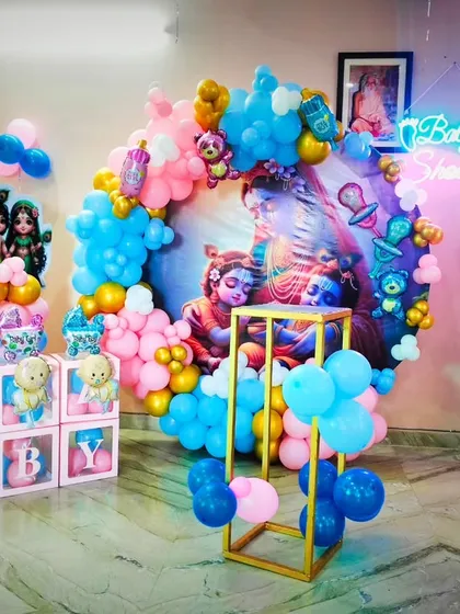 This full setup of the Kanha ji baby shower shows the central balloon ring, character pillars, and 'BABY' blocks, demonstrating a complete and cohesive themed decoration package.
