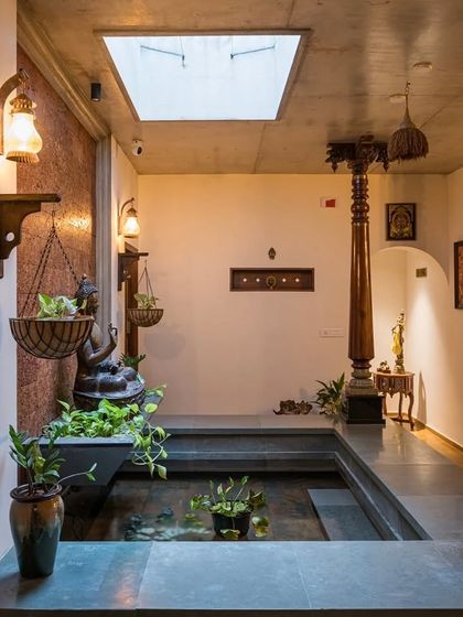 The sky-lit courtyard, with its water feature and hanging plants, acts as a microclimate, naturally cooling the home.