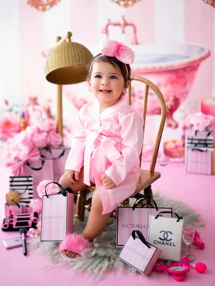 A perfect pose in her little chair, looking absolutely adorable in her pink robe and fluffy slippers.