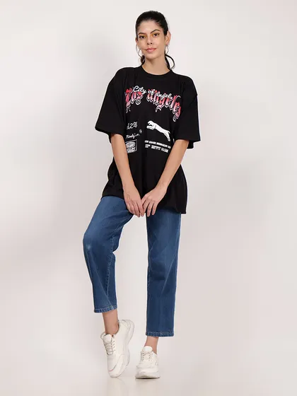 A full-length shot that shows how the oversized t-shirt is styled with jeans and sneakers, offering outfit inspiration.