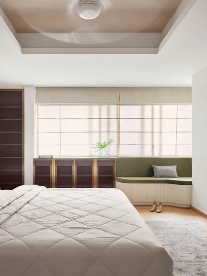 In this master bedroom, I integrated form and function with custom floor-to-ceiling wardrobes in a bold, dark finish with brass accents. The design is complemented by a custom window seat with built-in storage, creating a cozy reading nook that is both beautiful and practical.