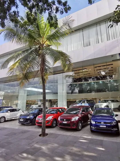The exterior of a transformed Maruti Suzuki Arena showroom in Bangalore. The design features a modern glass facade that maximizes visibility into the showroom, creating a strong street presence and inviting customers inside.