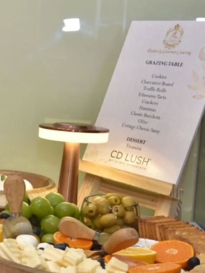A close-up of the custom menu and cheese board for the CD Lush event. The warm lighting and fresh ingredients create a welcoming and luxurious feel.