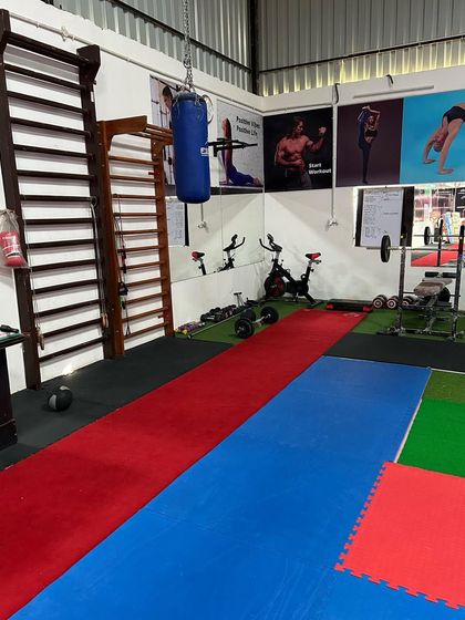 A look at our strength and conditioning area, which includes a wall ladder, punching bag, and free weights, supplementing our gymnastics and calisthenics training.
