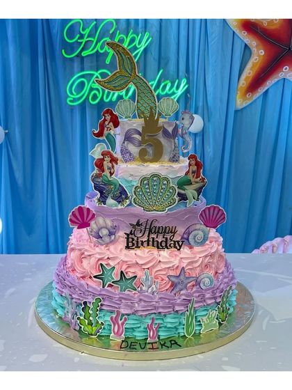A spectacular 5-tier mermaid theme cake for a 5th birthday. Made entirely with whipping cream, this cake features multiple colors, textures, and under-the-sea details.