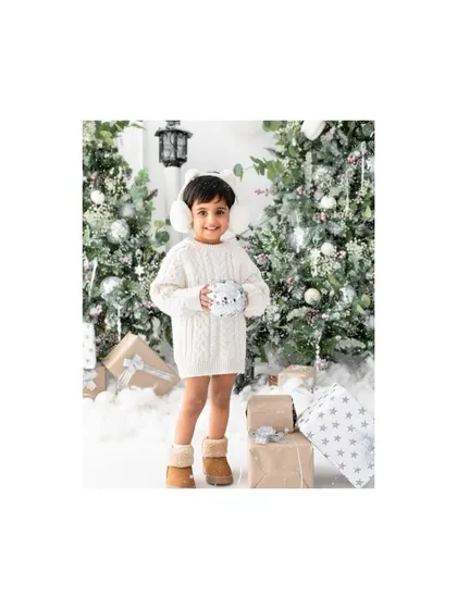 Holding a snowball in our winter wonderland studio setup. I love creating these immersive scenes for my Christmas mini sessions to make them extra special.