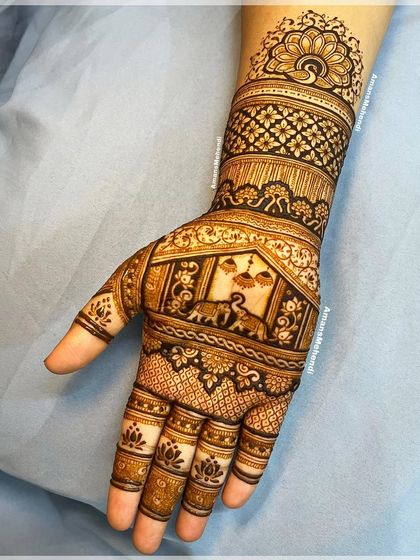 A full hand design featuring a procession of elephants and a central peacock motif. The intricate details and dense patterns make this a stunning bridal choice.