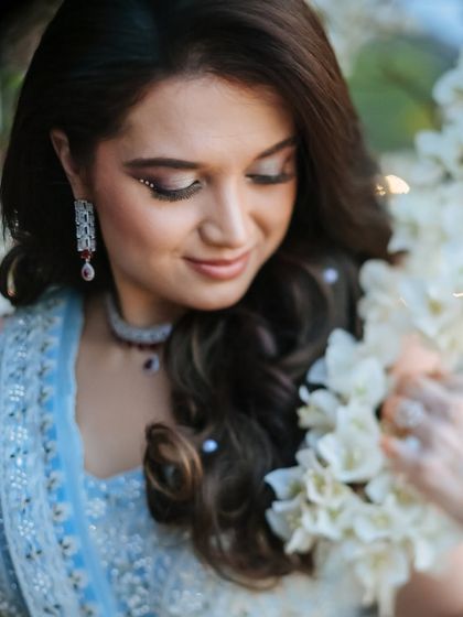 A beautiful close-up of a bride, her face framed by white flowers, her expression soft and gentle.