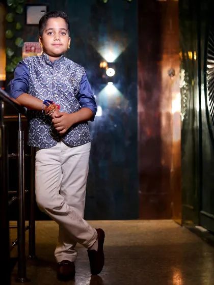 A posed shot of the birthday boy in a stylish hallway, using the architectural elements and lighting to create a dramatic portrait.