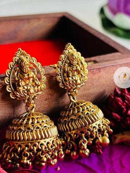Introducing our exquisite temple jewellery jhumkas. These earrings feature a detailed Goddess Lakshmi stud with a large, intricately carved jhumka base.