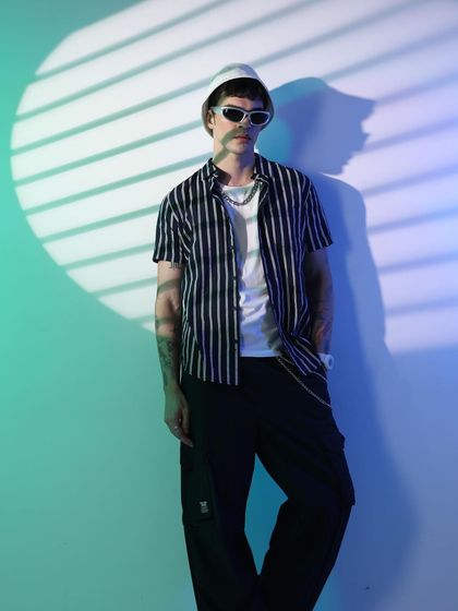 Cyberpunk visions for Highlander. I used striped lighting effects and a cool color palette to create this futuristic look, styling a simple striped shirt with a bucket hat and modern sunglasses.