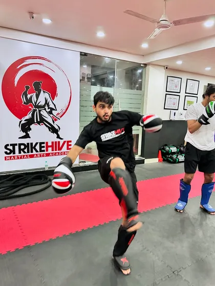 A student practices a front kick during a drill. This dynamic shot captures the energy and movement that make our classes an exciting alternative to traditional gym workouts.