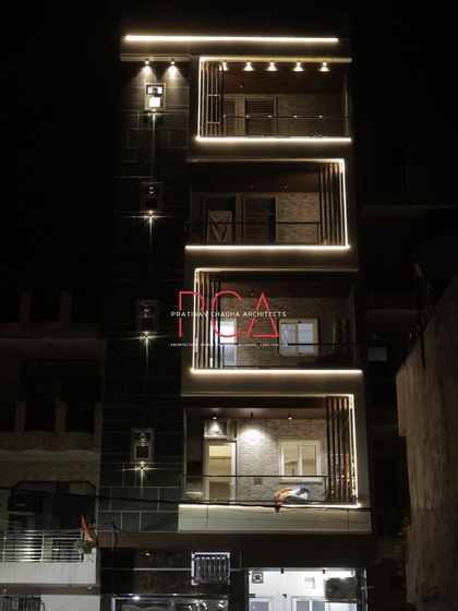 The residence at night, with warm interior light visible from the balconies. This view creates a sense of a lived-in, opulent home, connecting the exterior architecture with the life inside.