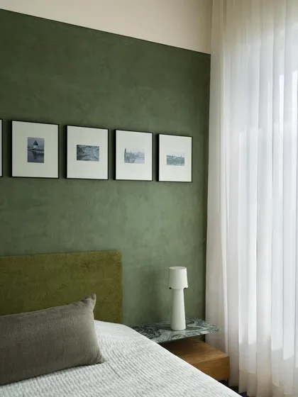 This master bedroom from our Barefoot House project shows our use of layered textures and colours to create tranquility. The deep green lime plaster wall provides a soothing backdrop, making the room a true haven from the city.