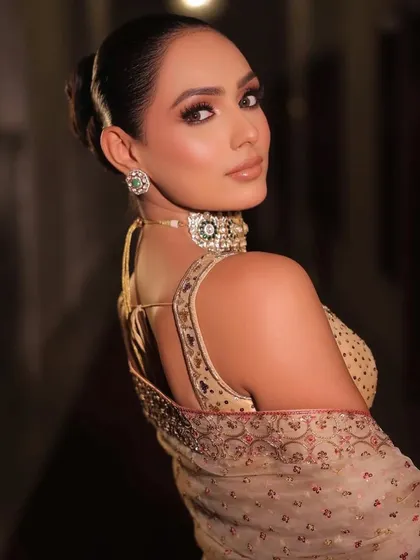 A back view of the golden saree look, showcasing the elegant low-back blouse and the sleek bun hairstyle I recommended.
