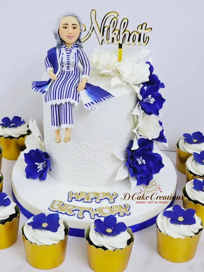 For Nikhat Khan's birthday, I designed this elegant cake and matching cupcakes. The centerpiece is a custom figurine of her, perfectly matching her blue and white striped birthday outfit.