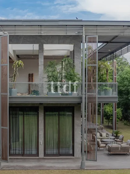 We designed this modern home to breathe with its natural surroundings. The structure uses raw concrete, warm wood, and expansive glass to dissolve the boundaries between the interior and the lush greenery outside, creating a seamless indoor-outdoor living experience.