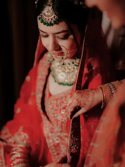 A close up of the bride adjusting her red dupatta, a moment of quiet preparation before the main ceremony.