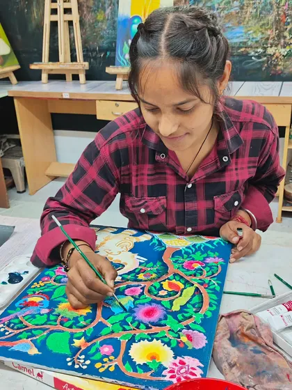 A student painting a ceramic piece, adding vibrant colors to a pre-made object. This is a great way to learn about painting on different surfaces.