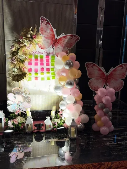 This wishing board area was part of a larger butterfly-themed decoration. It features large butterfly cutouts, floral arrangements, and balloon pillars, creating an interactive and beautiful corner for guests.
