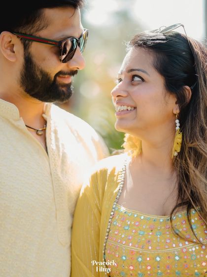 A close-up of the couple looking at each other with love and laughter. A perfect candid moment from their sun-kissed Haldi celebration.