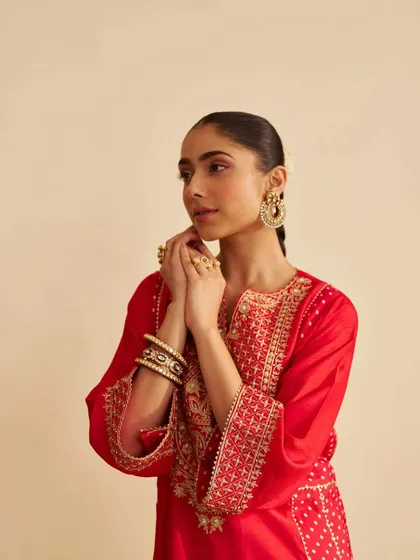 A model looking radiant in a bright red kurta with delicate gold embroidery. The look is classic, festive, and effortlessly elegant.