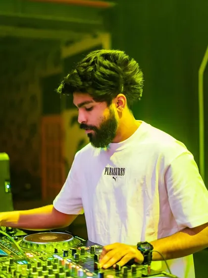 A focused shot of me at the decks at Sunburn Union, under a vibrant yellow light.