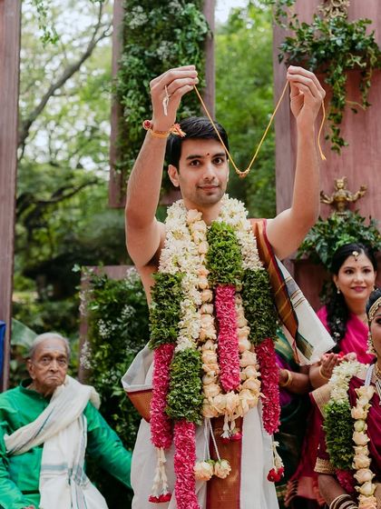 The groom holds up the sacred 'mangalsutra' before tying it, a pivotal moment in a Hindu wedding ceremony.