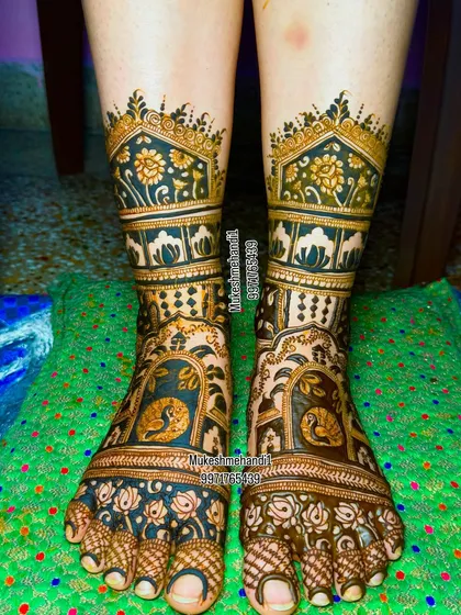 Bridal beauty extends to the feet. Here is a royal bridal foot design with intricate peacock motifs and palace-style architecture, ensuring every detail of your look is perfect from head to toe.