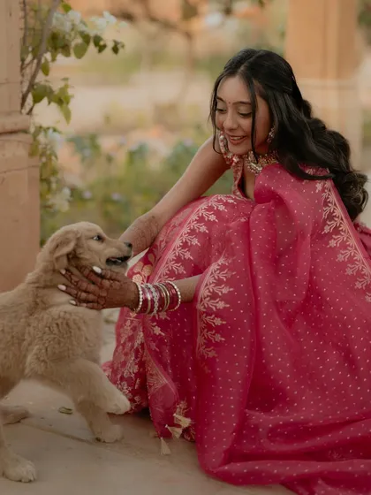 A heartwarming moment as the bride, Kajal, shares a cuddle with an adorable puppy. This photo brings a sense of warmth and genuine, unplanned joy to her portrait session.